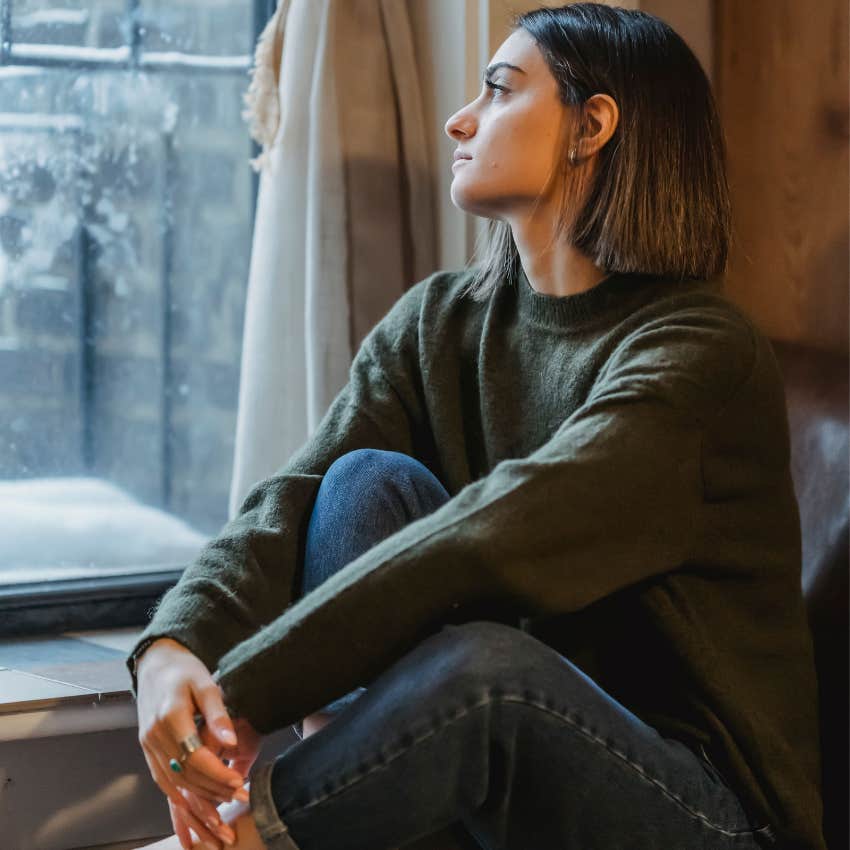 Woman with too much stress and no affection sits alone and withdrawn
