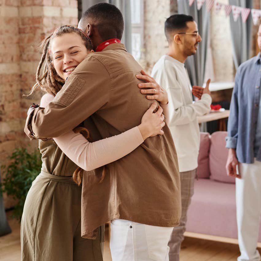 authentic woman hugging her ex at a party
