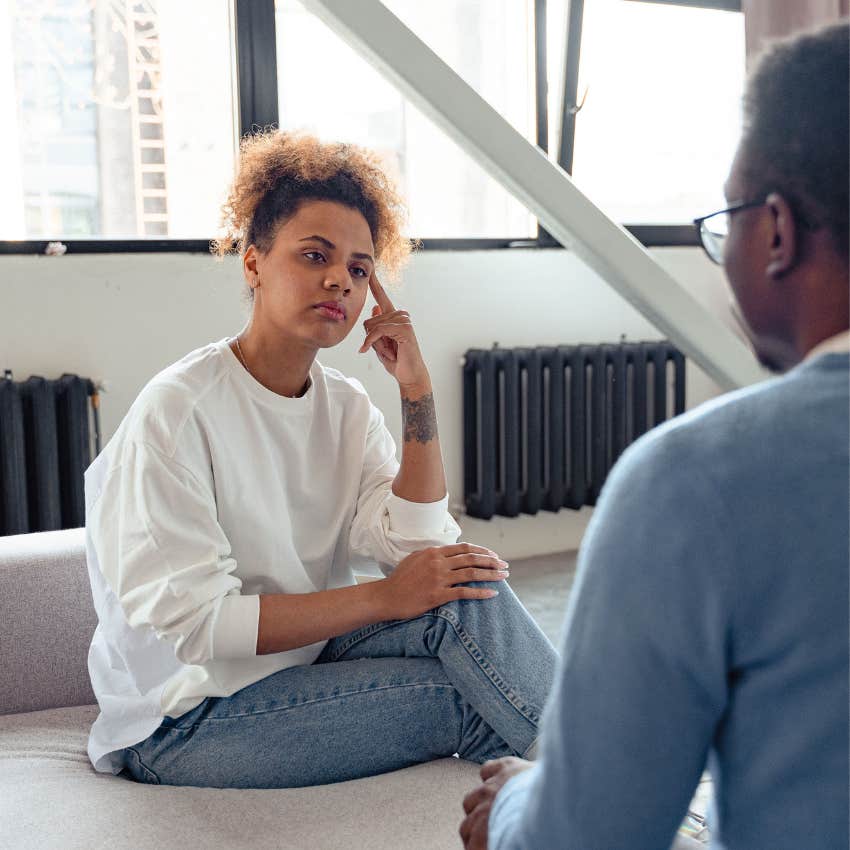 Woman listening thoughtfully while a man apologizes