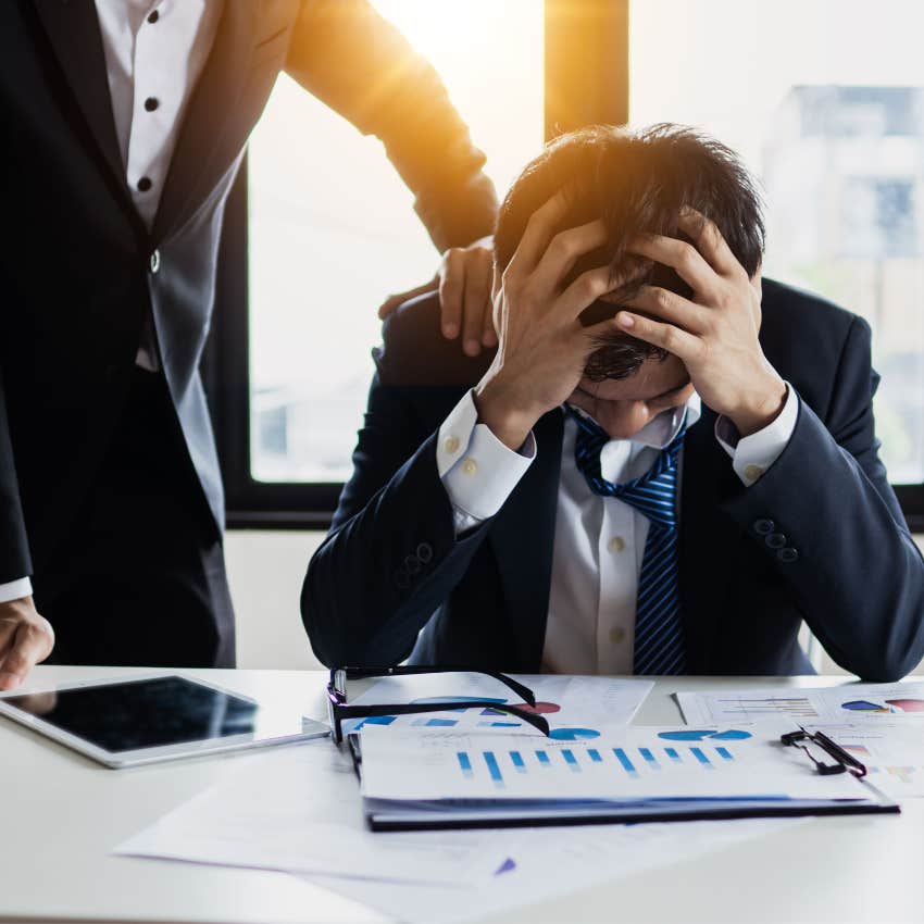 Frustrated employee reacting defensively while a manager checks on their work