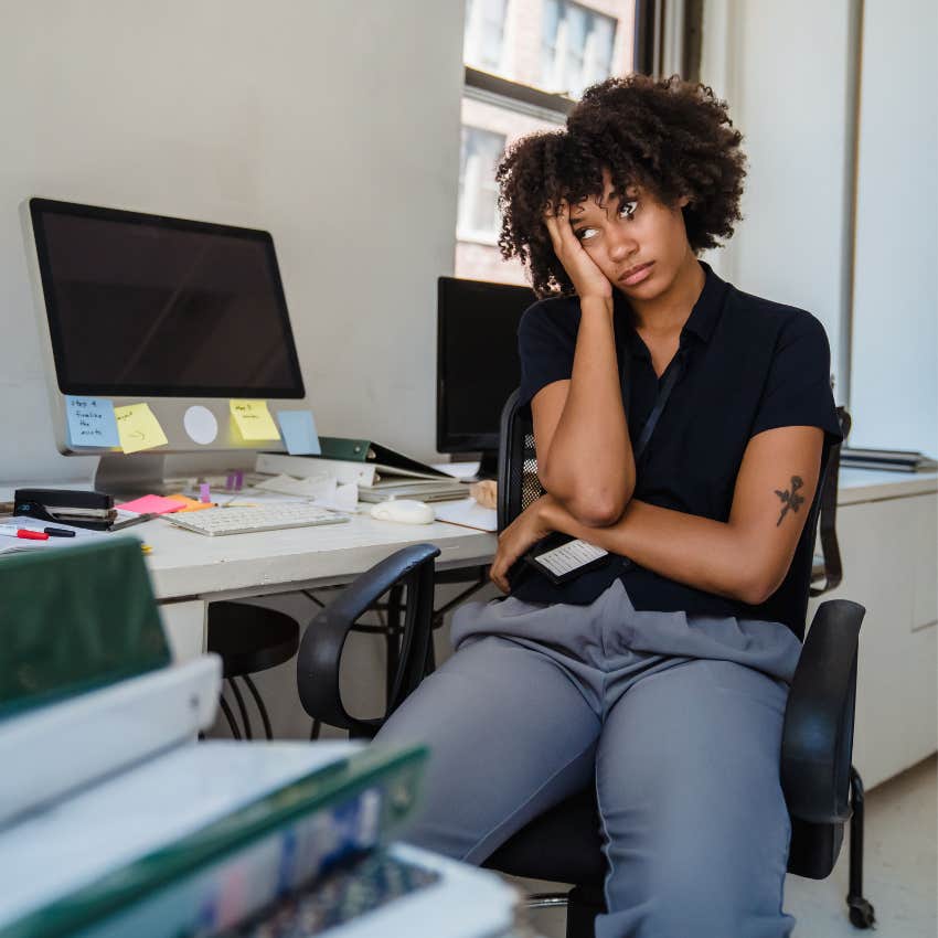 Tired employee looking frustrated while checking the time before starting an early morning work shift