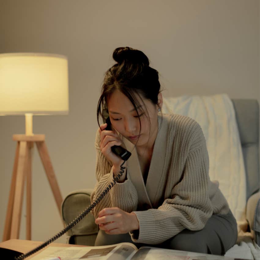 Teenager flipping through a large phone book at home while trying to find someone's telephone number