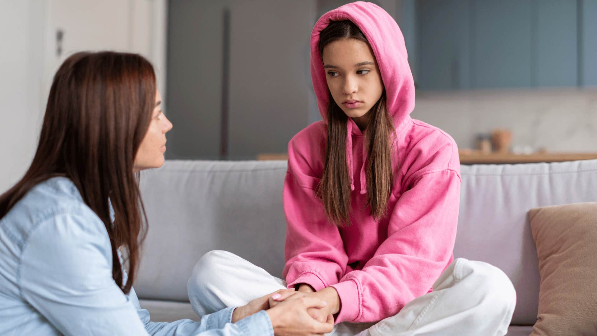 mother telling daughter in pink hoodie you're too young to worry about that