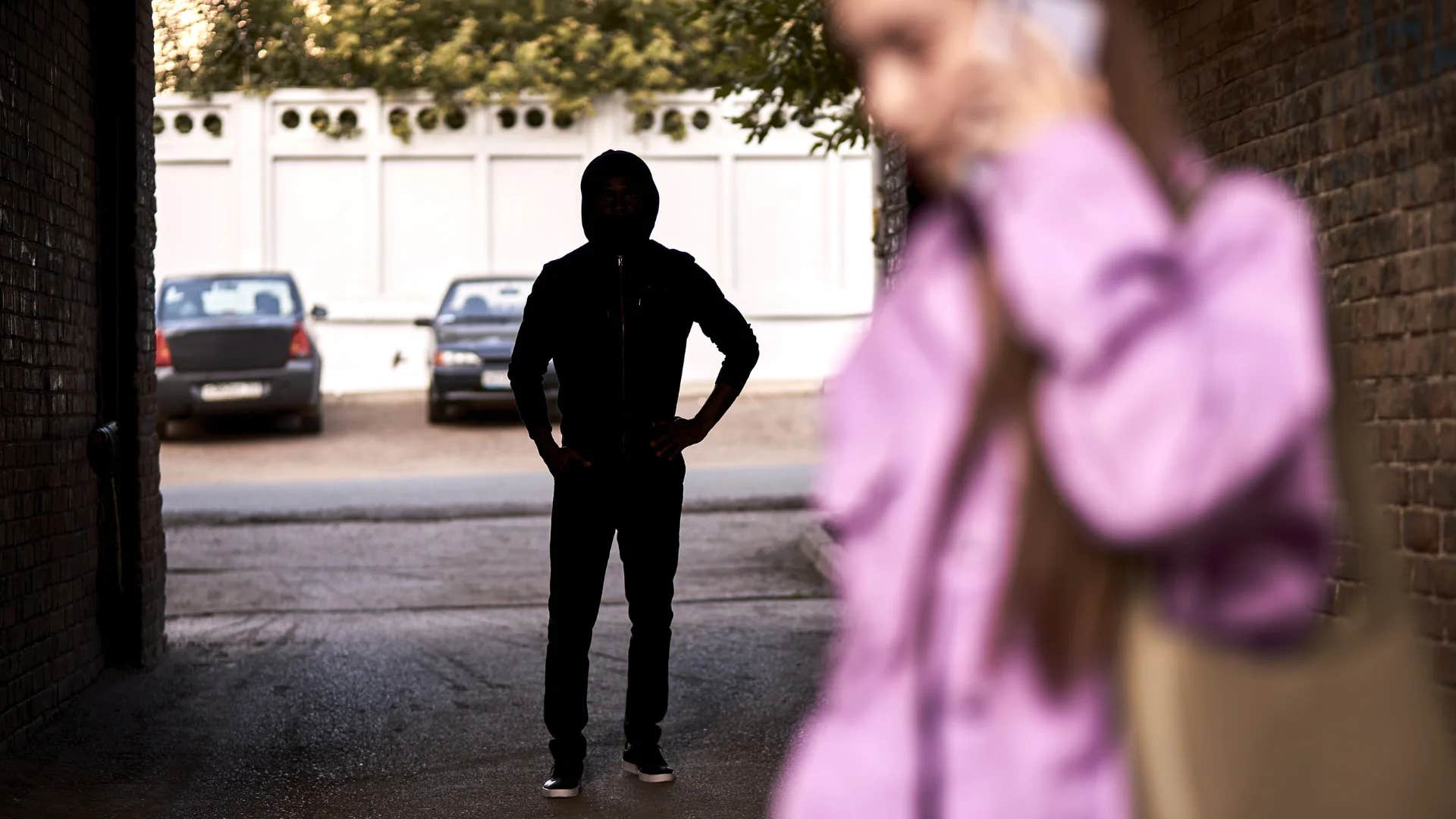 woman on the phone not noticing stranger in silhouette 