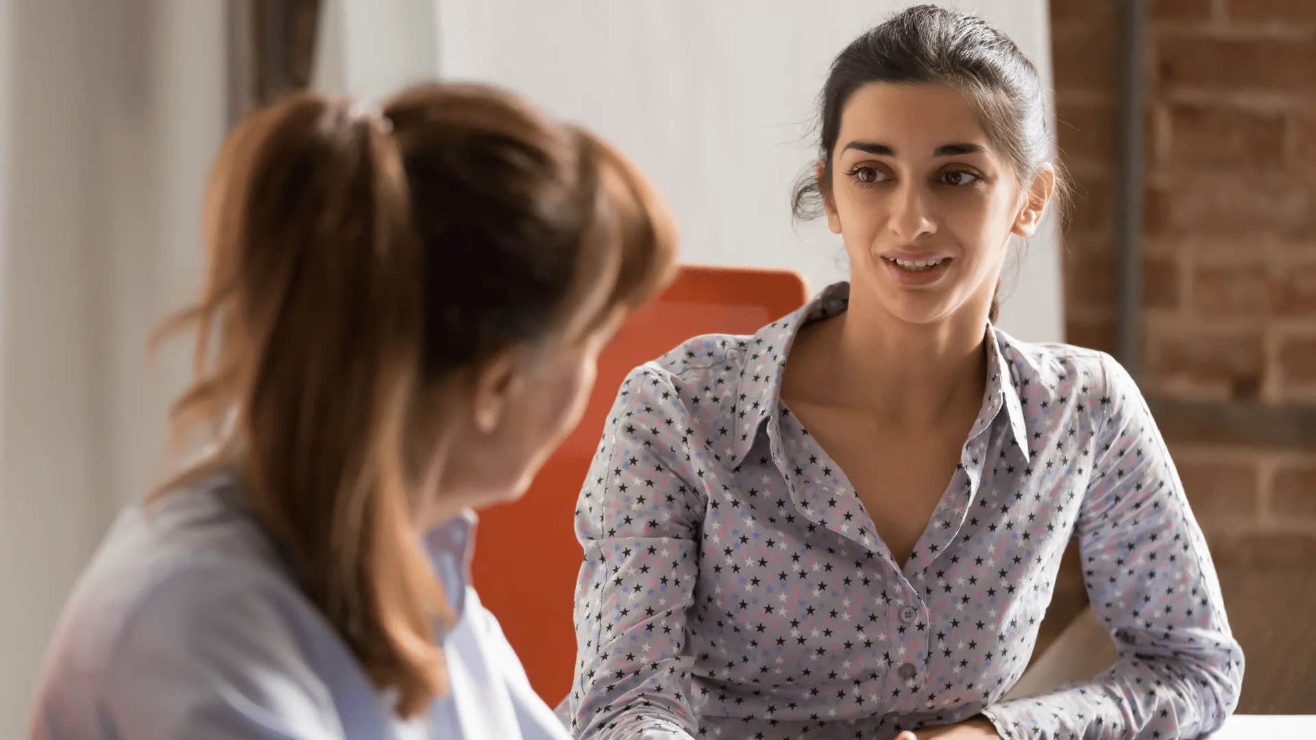 woman interrupting friend saying sorry to cut you off can we finish this conversation at a later date