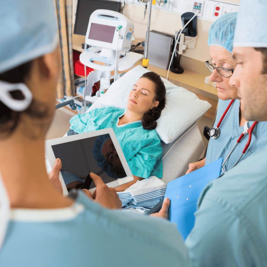 female patient in bed surrounded by surgeons