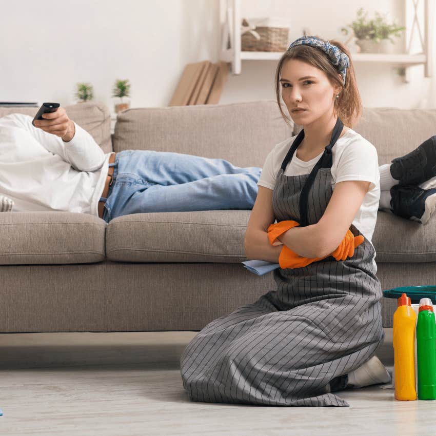 frustrated woman cleaning while man relaxes on couch