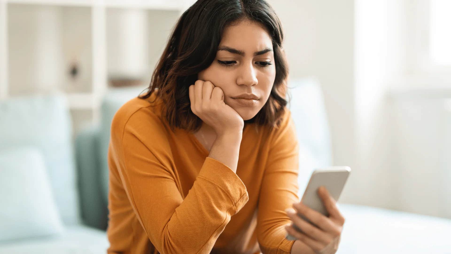woman avoiding calls from her mom looking at phone