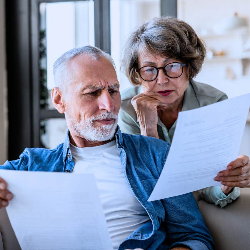 frugal boomer couple looking at printed out bills