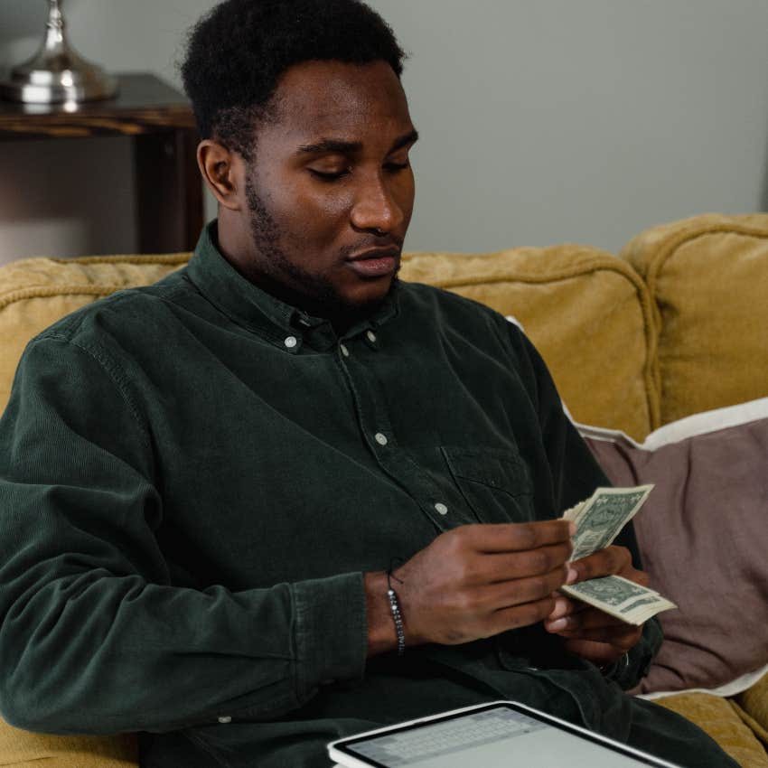 millennial man holding money to pay his bills