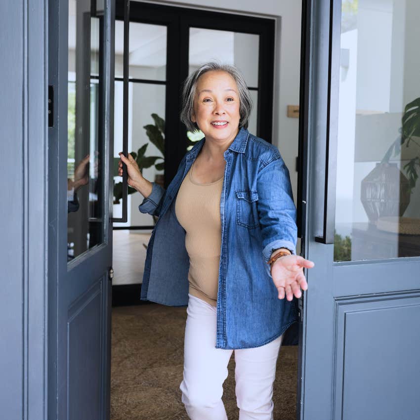 boomer woman expecting impromptu visits opening front door 