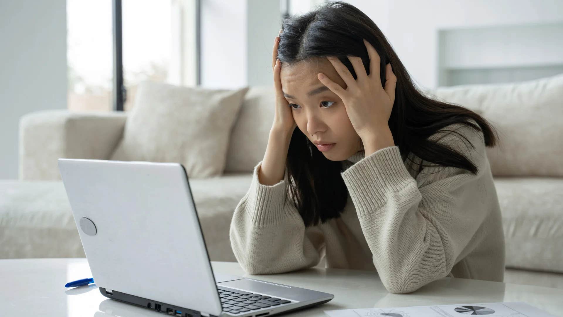 young Gen Z woman feeling anxious reading financial news headlines