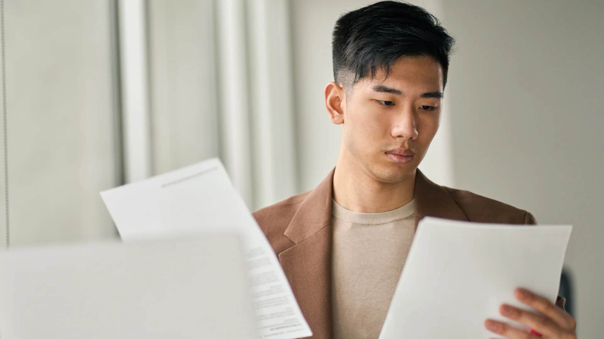 gen Z man stressed looking at bills to pay