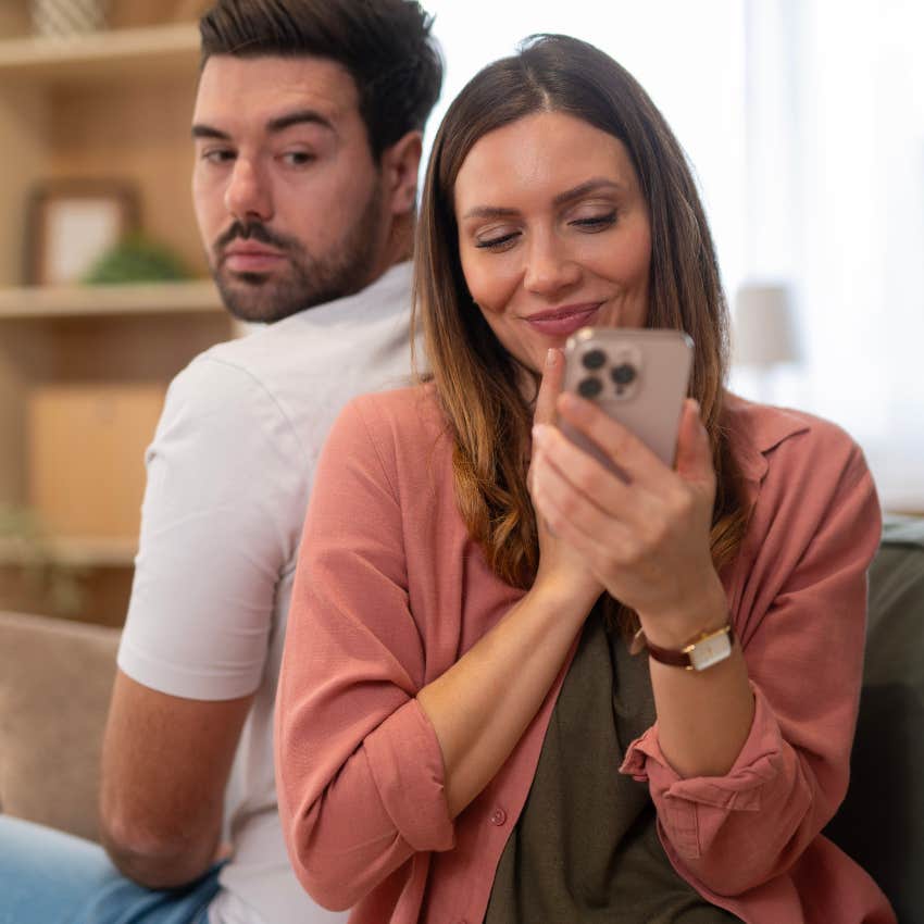 man who grew up with no privacy looking over his shoulder at girlfriend's texts