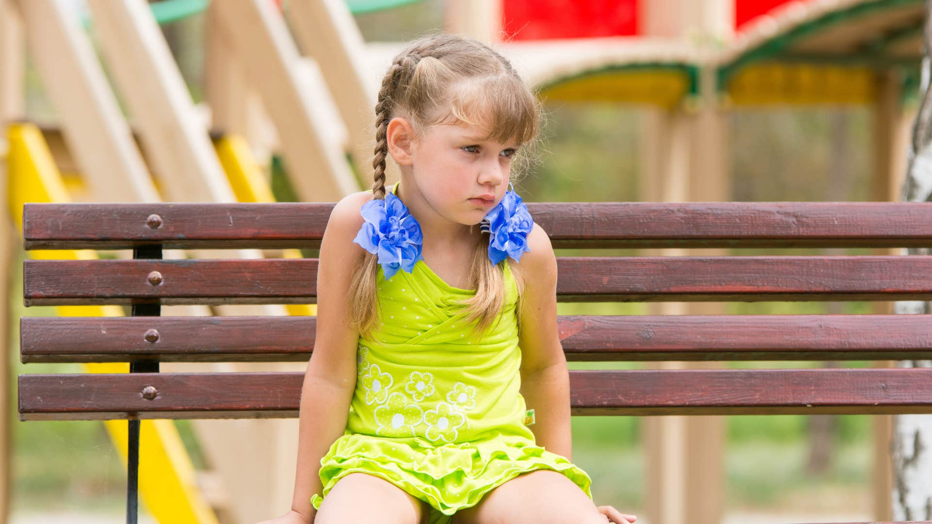 little girl in braids sitting by herself because she's overly independent
