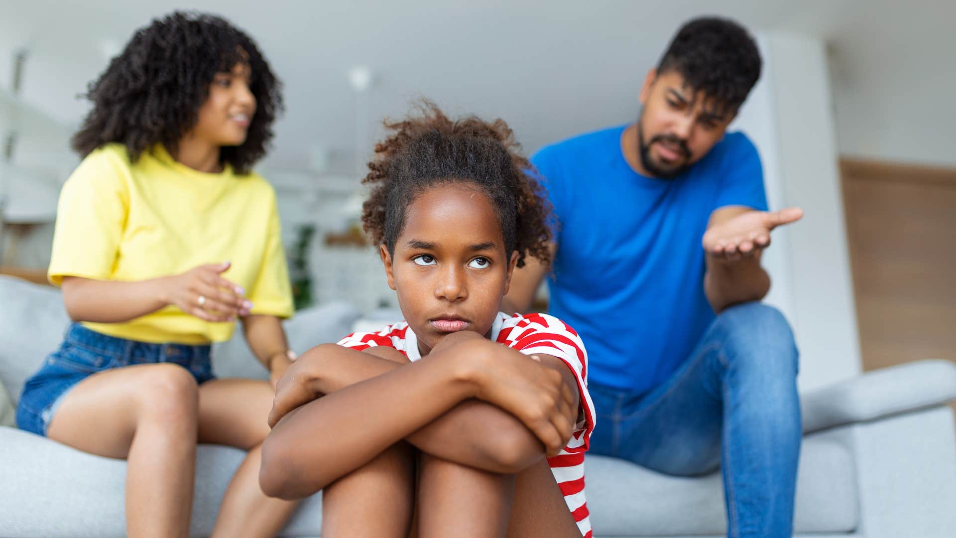 teen girl sitting with arm's crossed taking the blame because her parents never admit fault