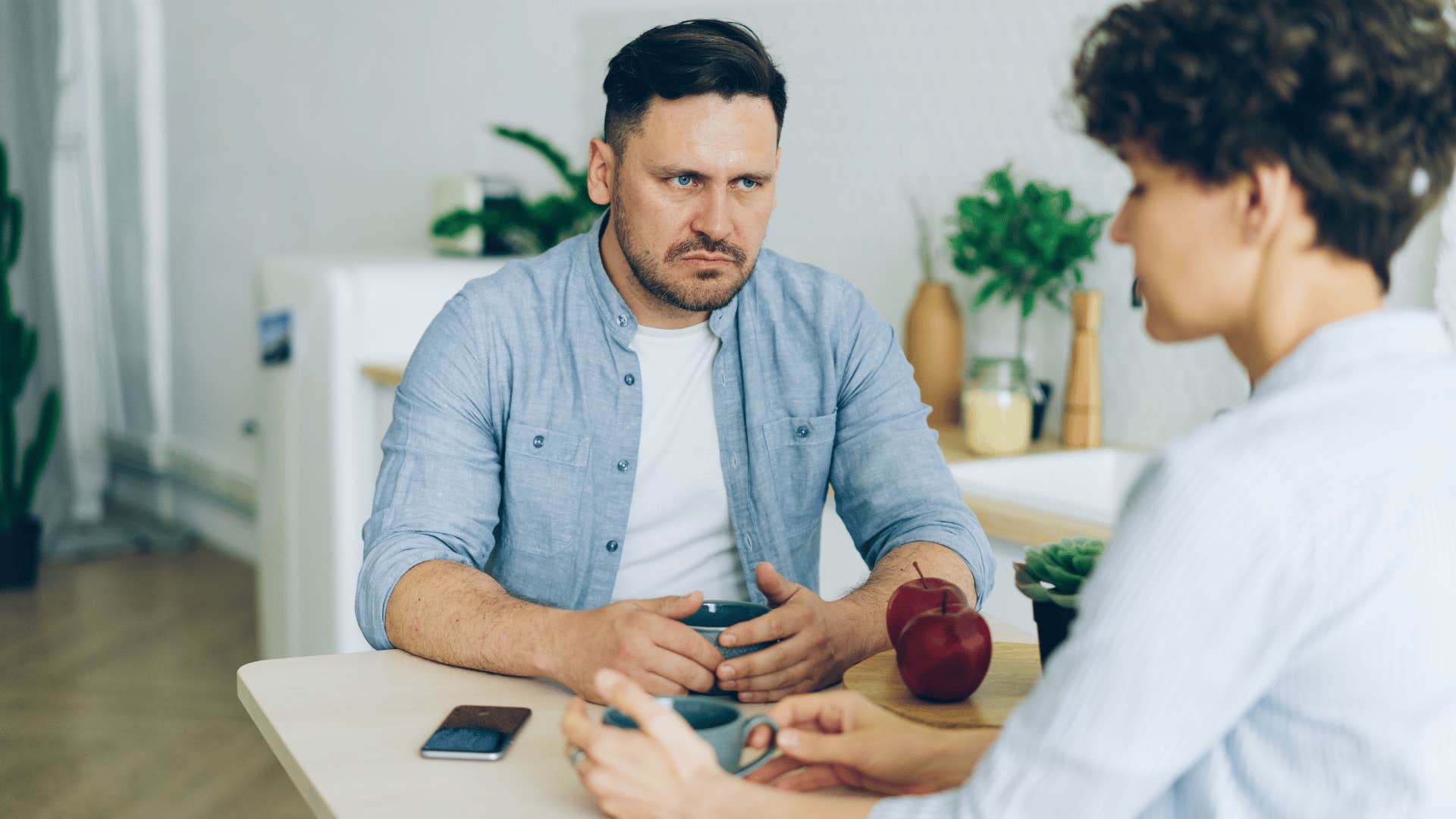 angry man monitoring his partner's emotions looking heated