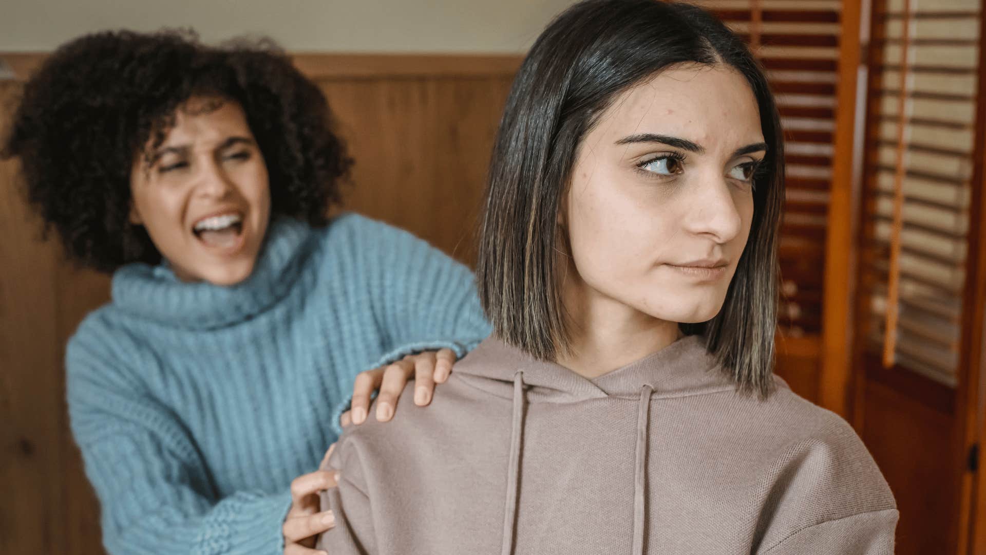sad young woman putting up with poor treatment from friend