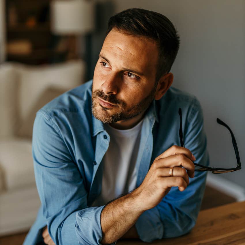 man slowly losing self-confidence holding his glasses while contemplating giving up on his project