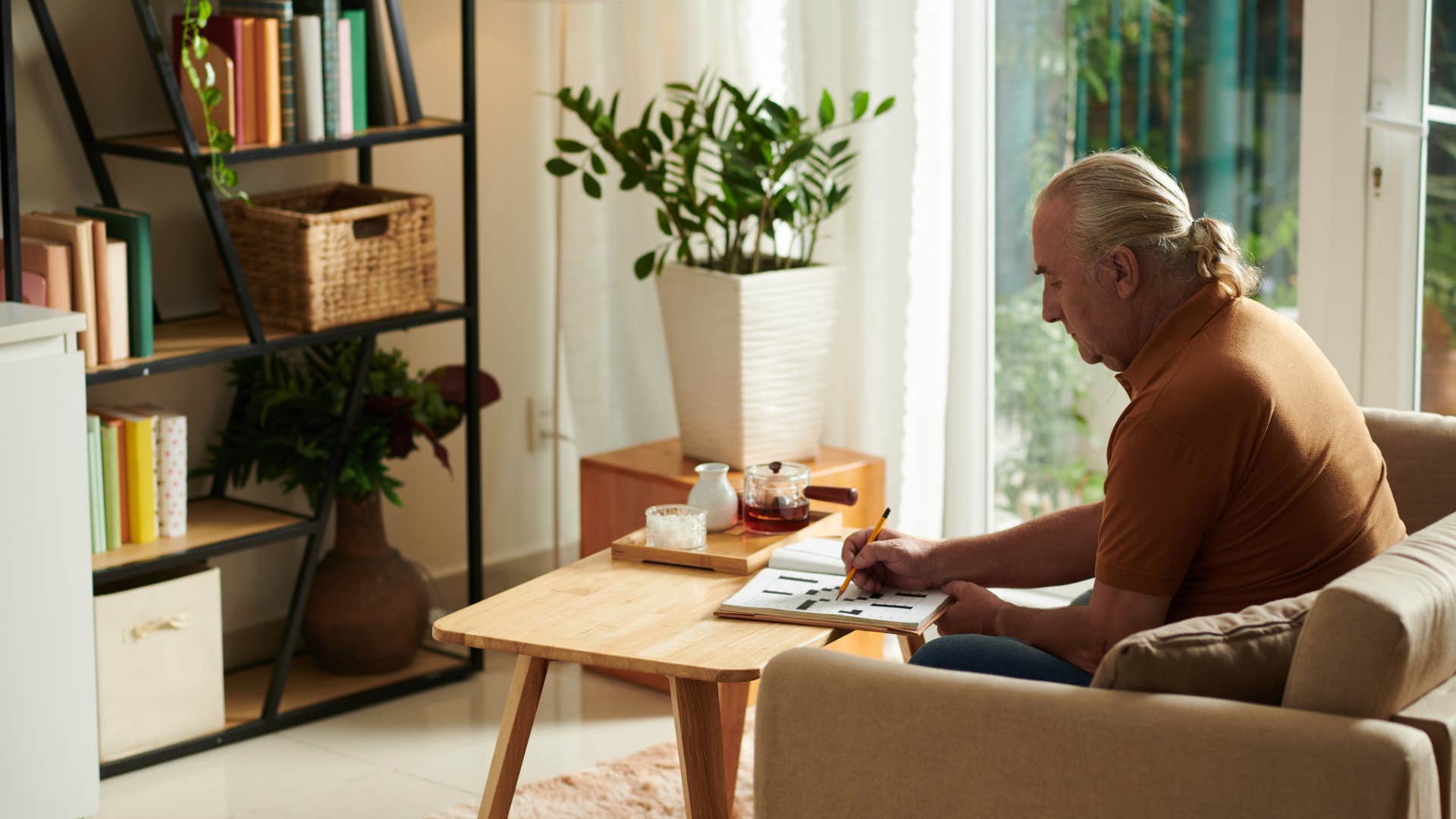 retired introvert man happily solving a brain-boosting crossword puzzle
