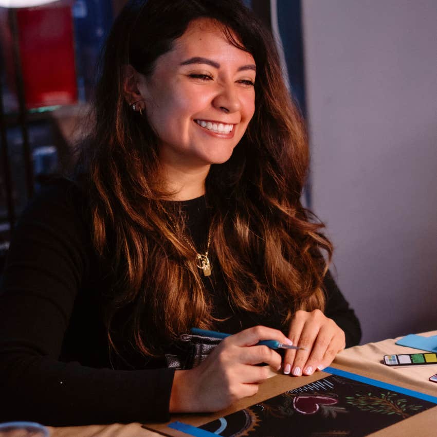 creative young woman drawing at home in her room alone