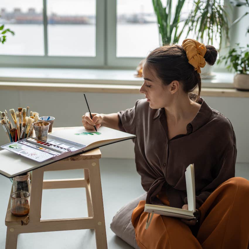fulfilled woman enjoying her creative hobby of painting
