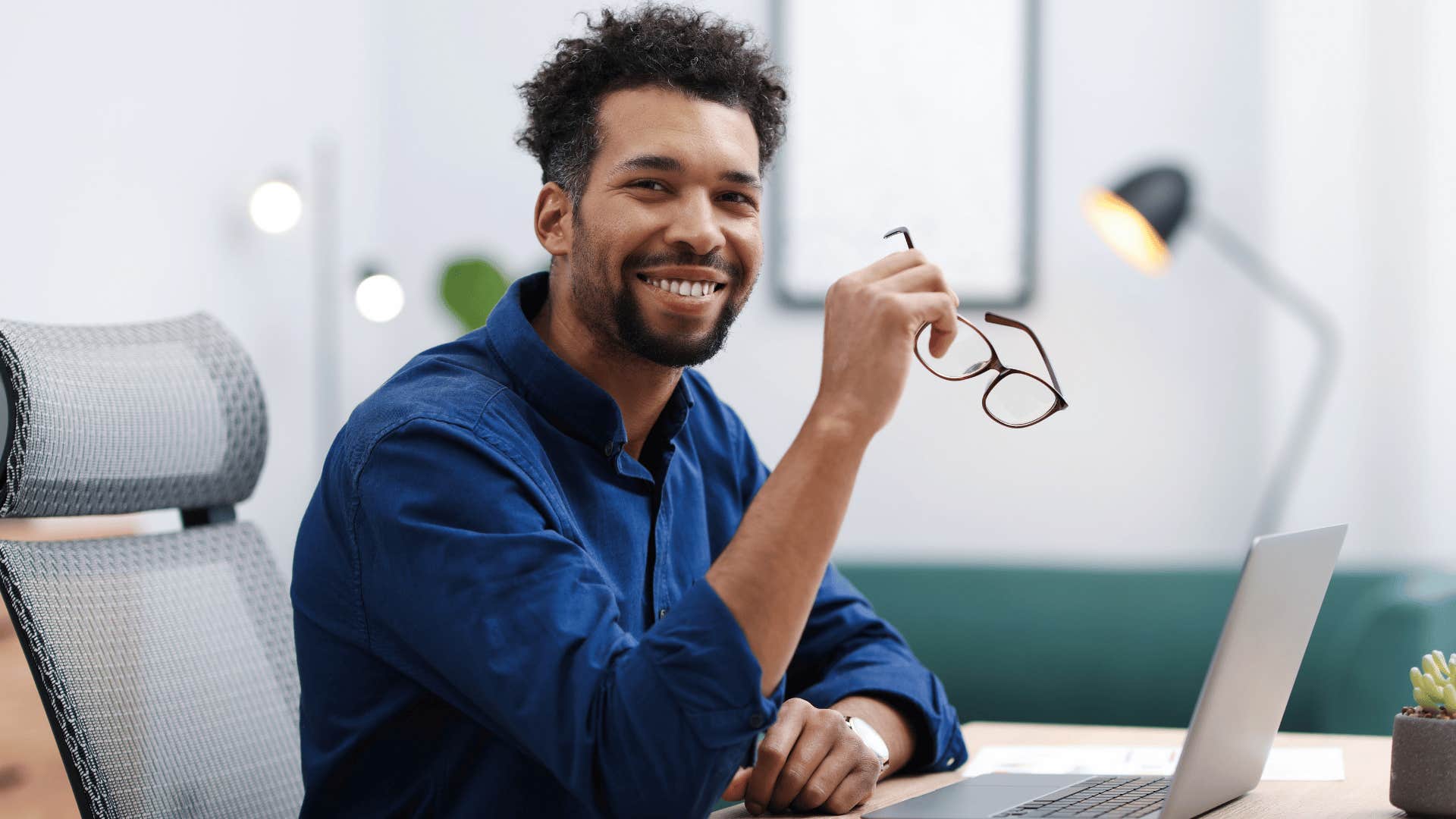 man in blue shirt has become hyper independent as he works at desk alone