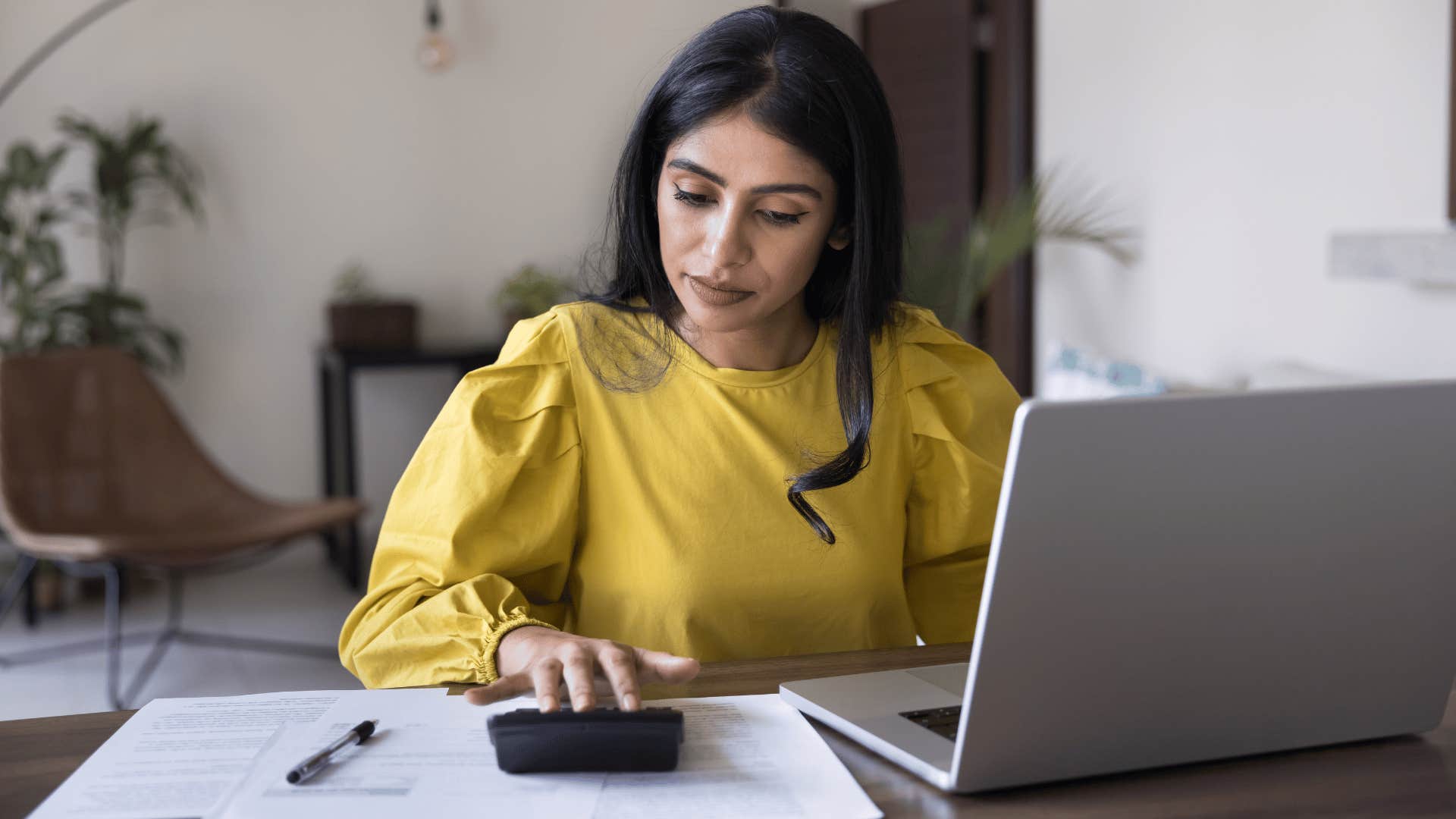 woman in yellow shirt checking their bank account every day