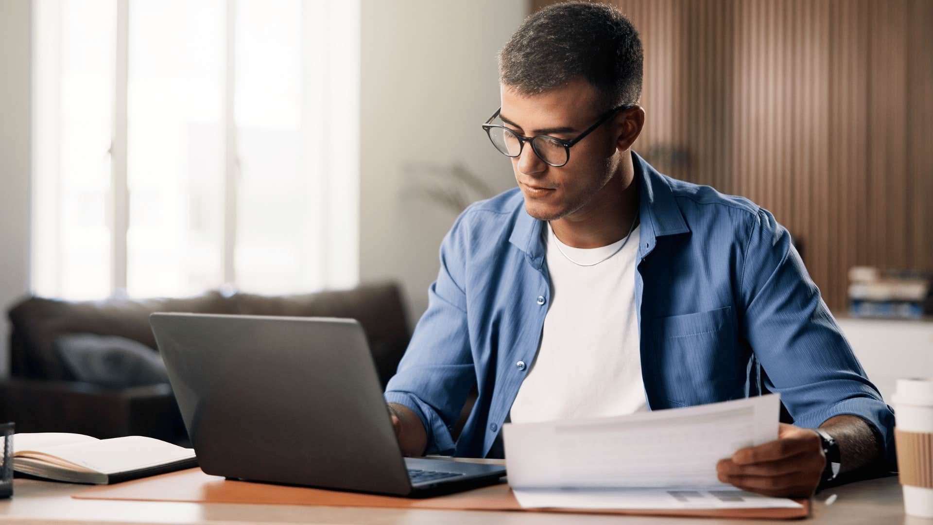 man in white shirt finishes tasks immediately as he works on laptop