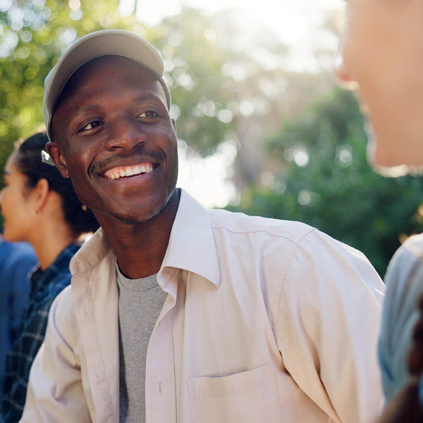 smiling man telling friend I'm so happy for you in conversation