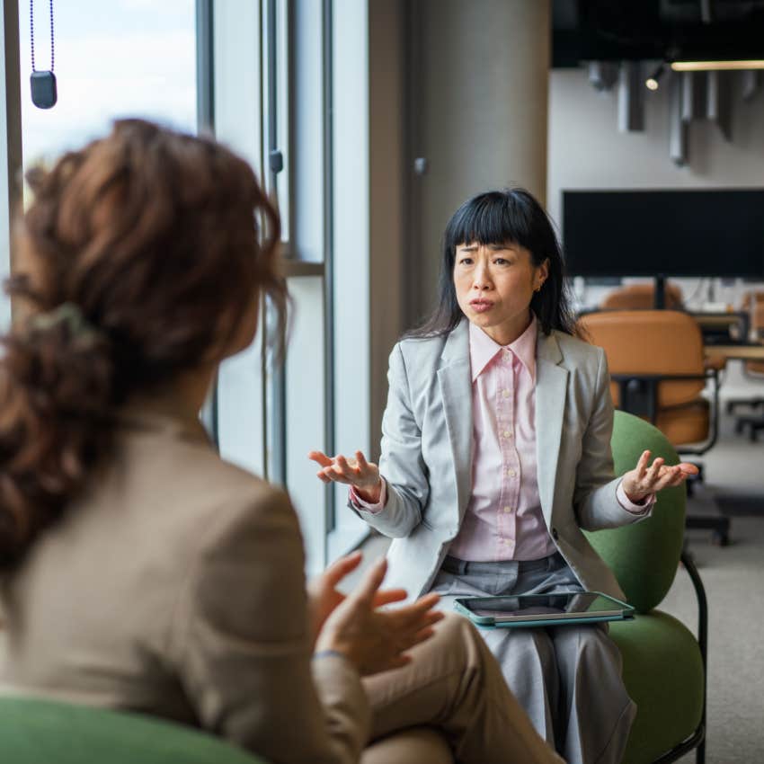 woman who tends to perform talking to colleague at work