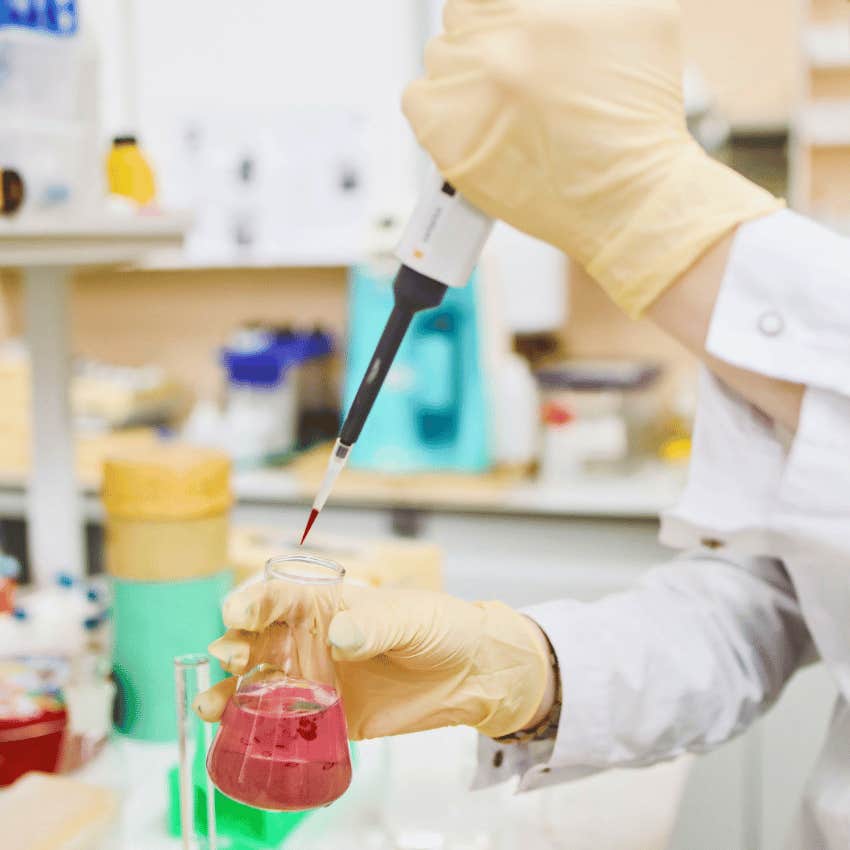 lab assistant holding pipette and beaker