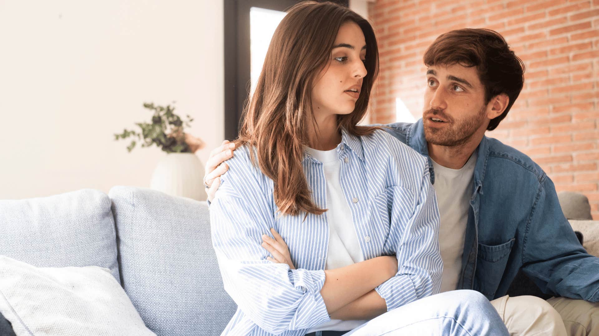 woman in white shirt crossing arms as she tells man if you loved me you'd
