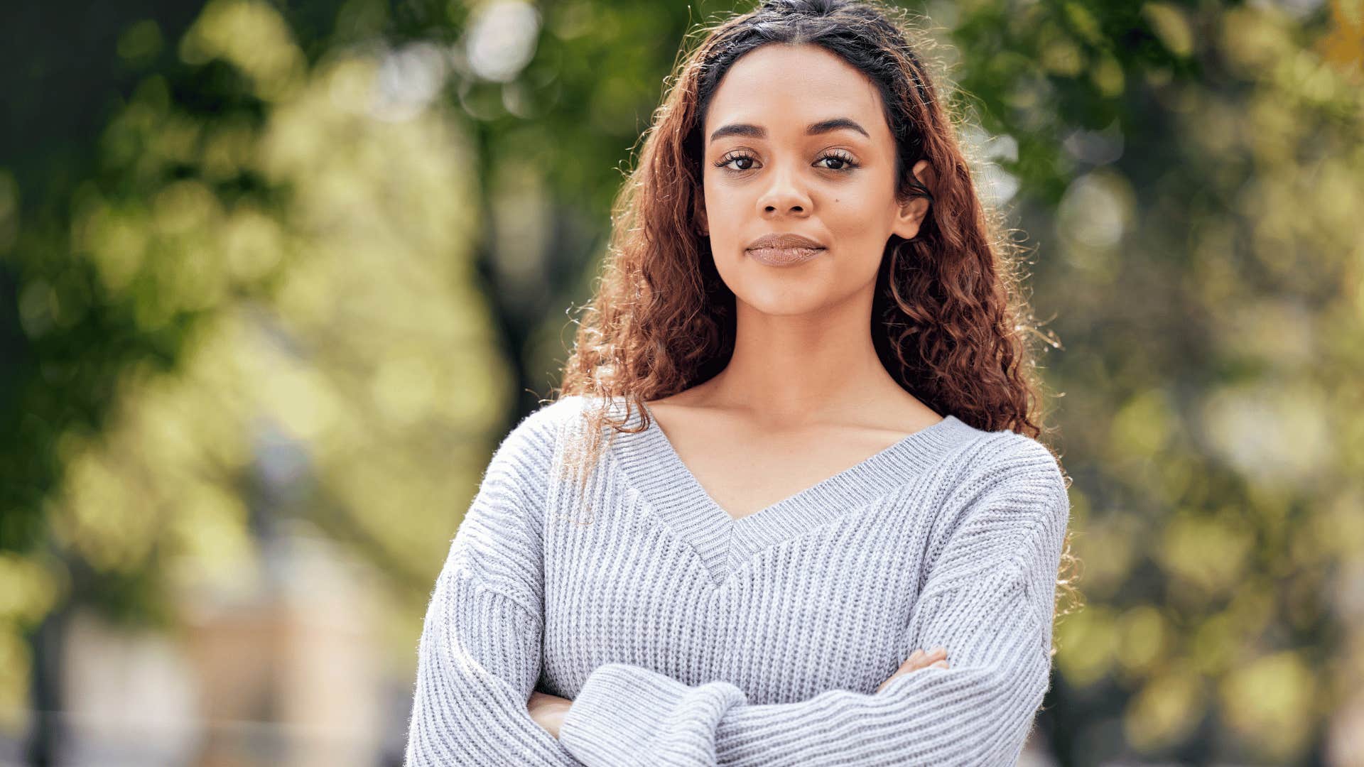 woman in gray sweater crossing arms as she thinks i'm not changing for anyone