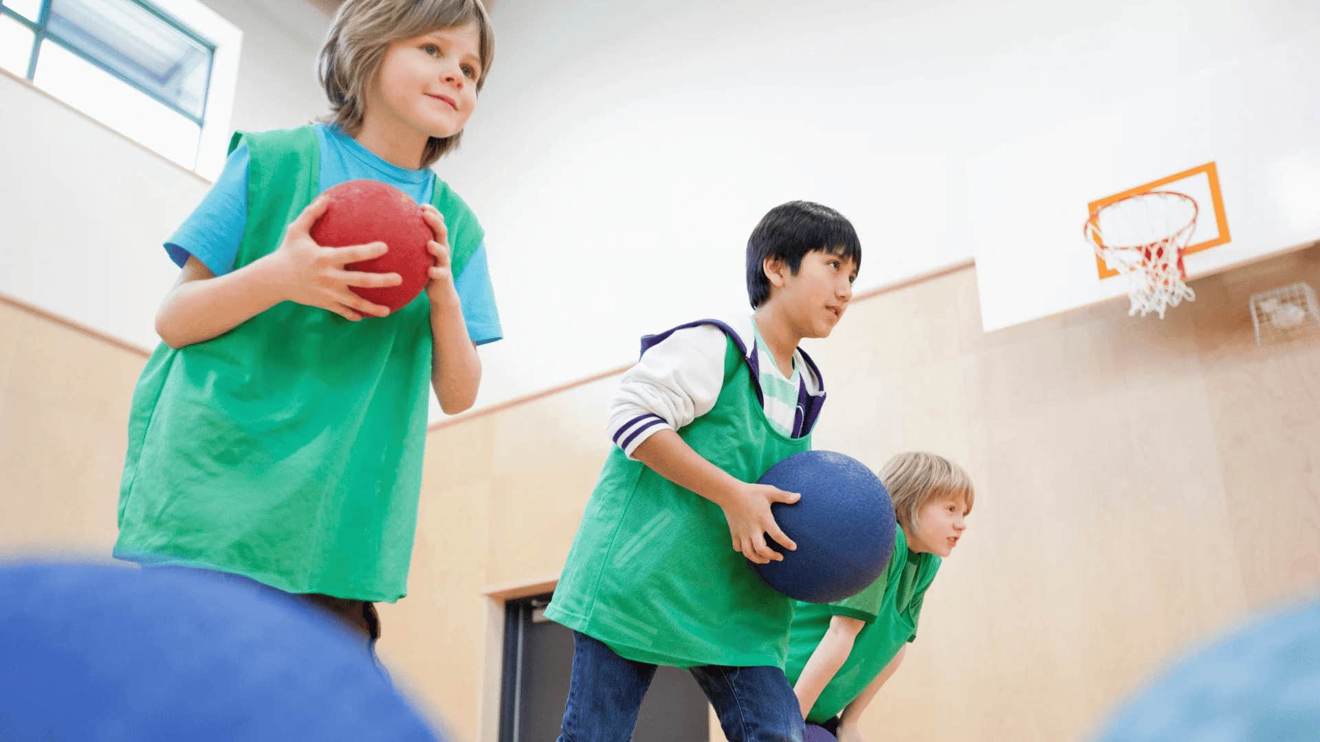 kids playing dodgeball in gym class at school