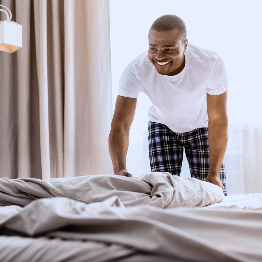 Man making his bed in the morning