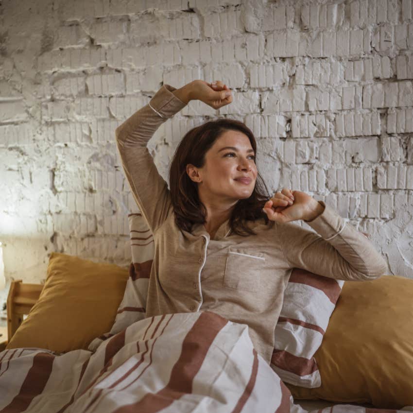 Woman stretching instead of looking at her screen in the morning