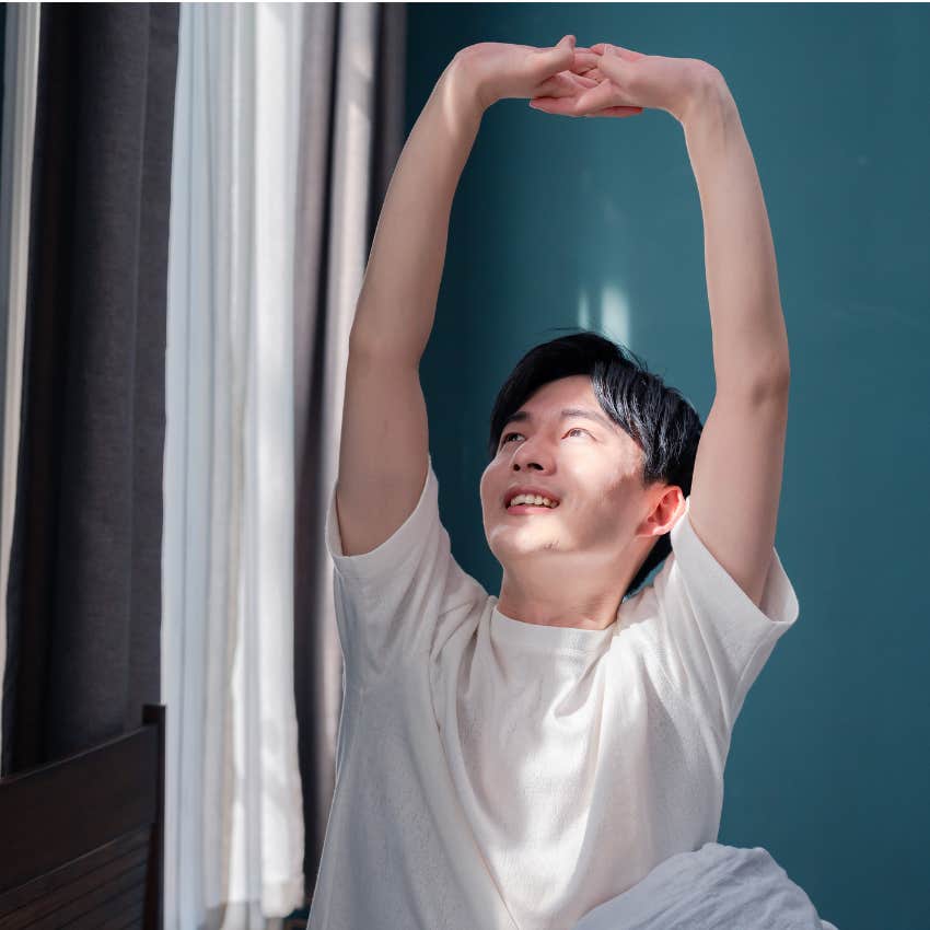 Man waking up with the sun at home in bed.