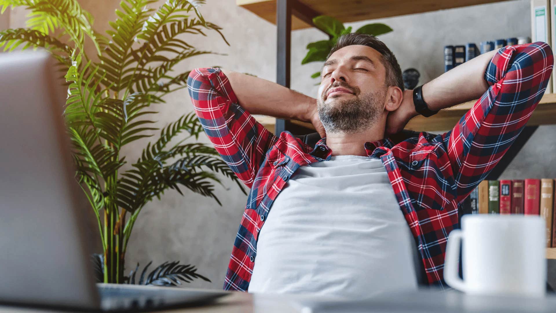 man taking a quick nap at his desk during the day at work