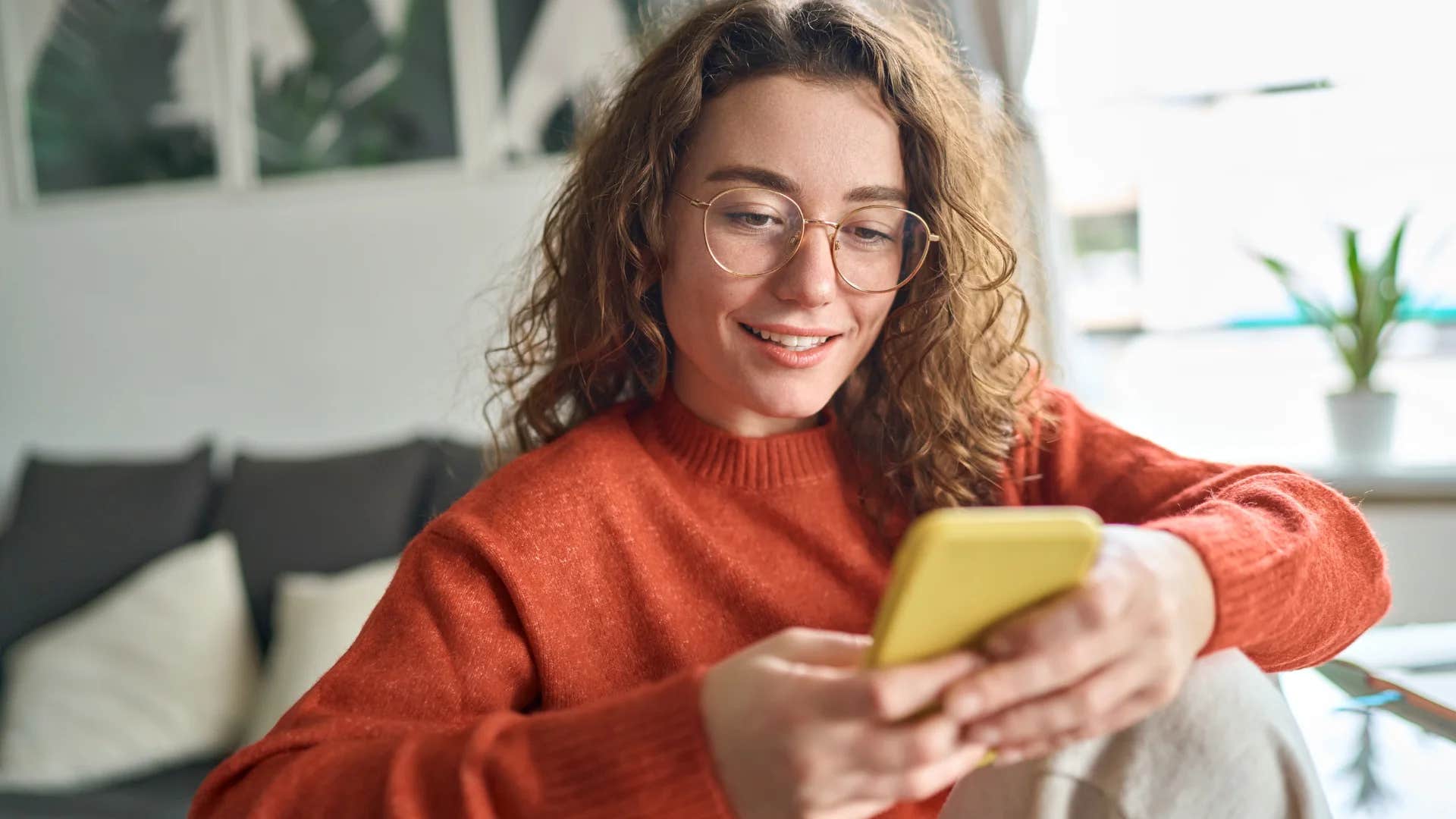 young woman using her phone in work lounge