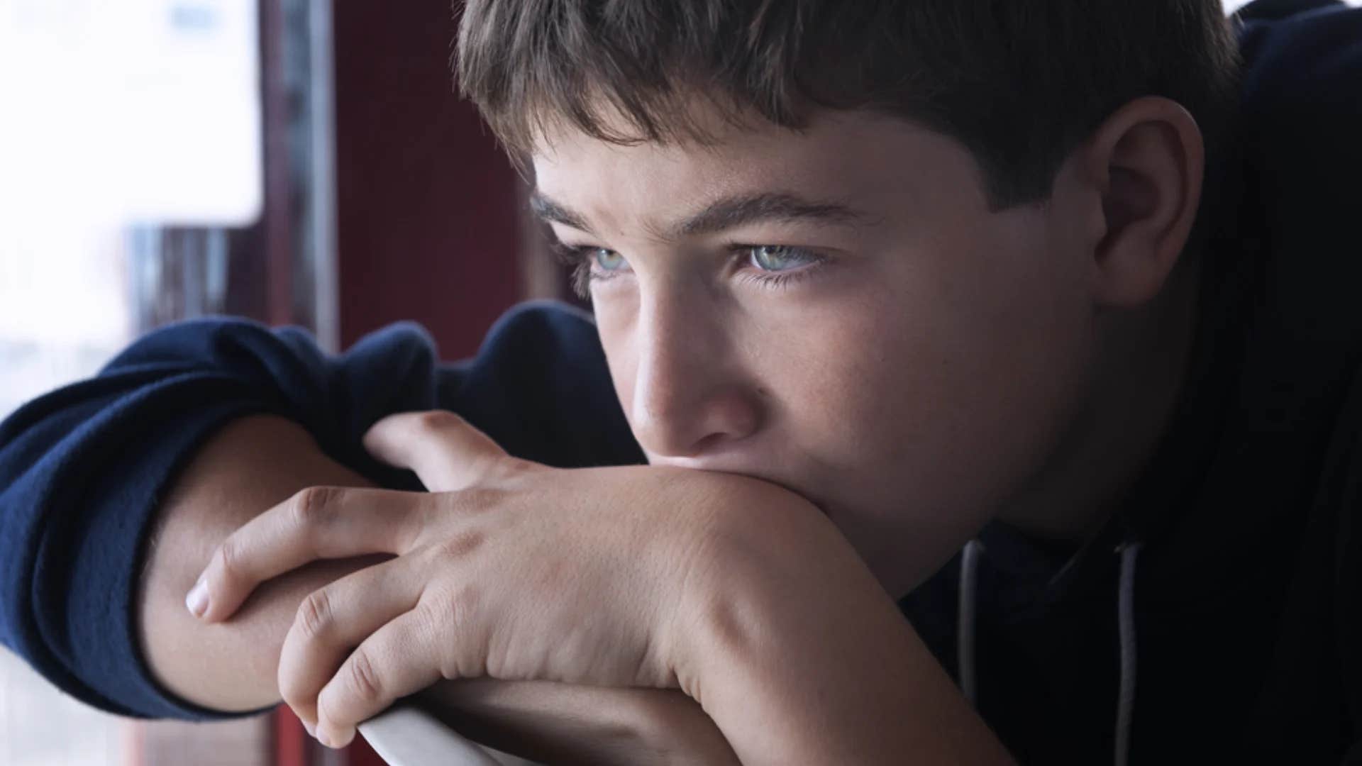emotionally detached little boy staring into the distance