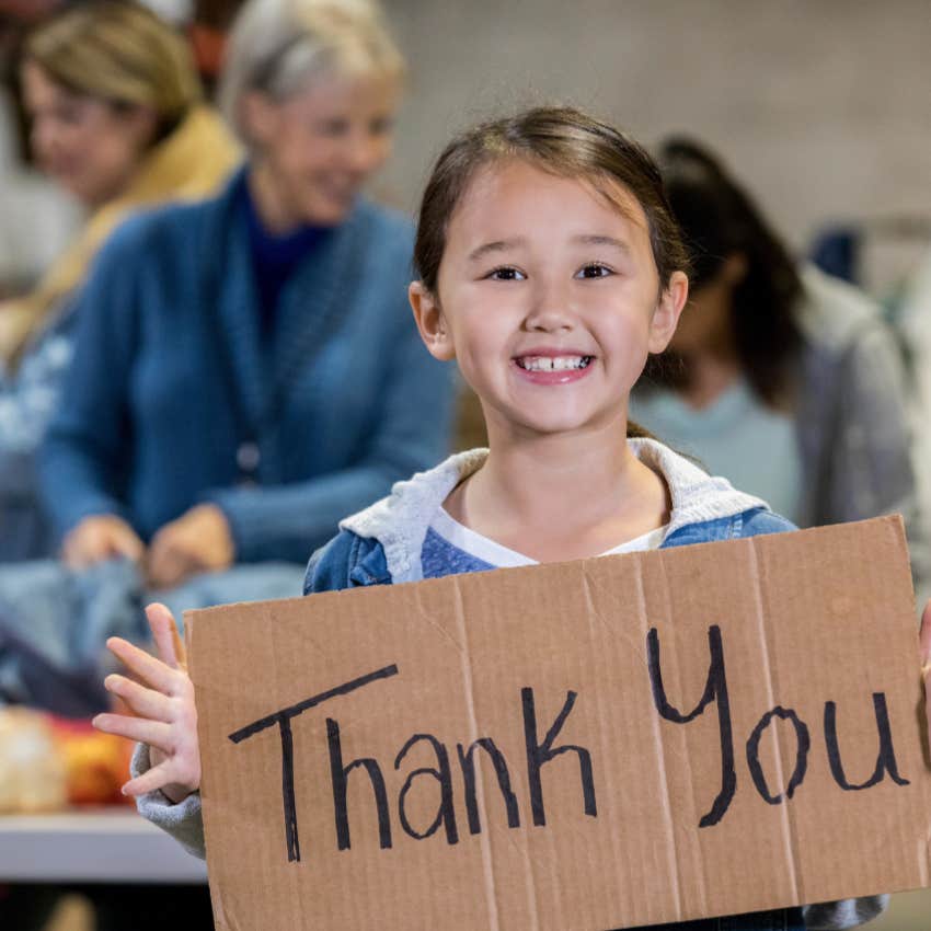kid holding a thank you note