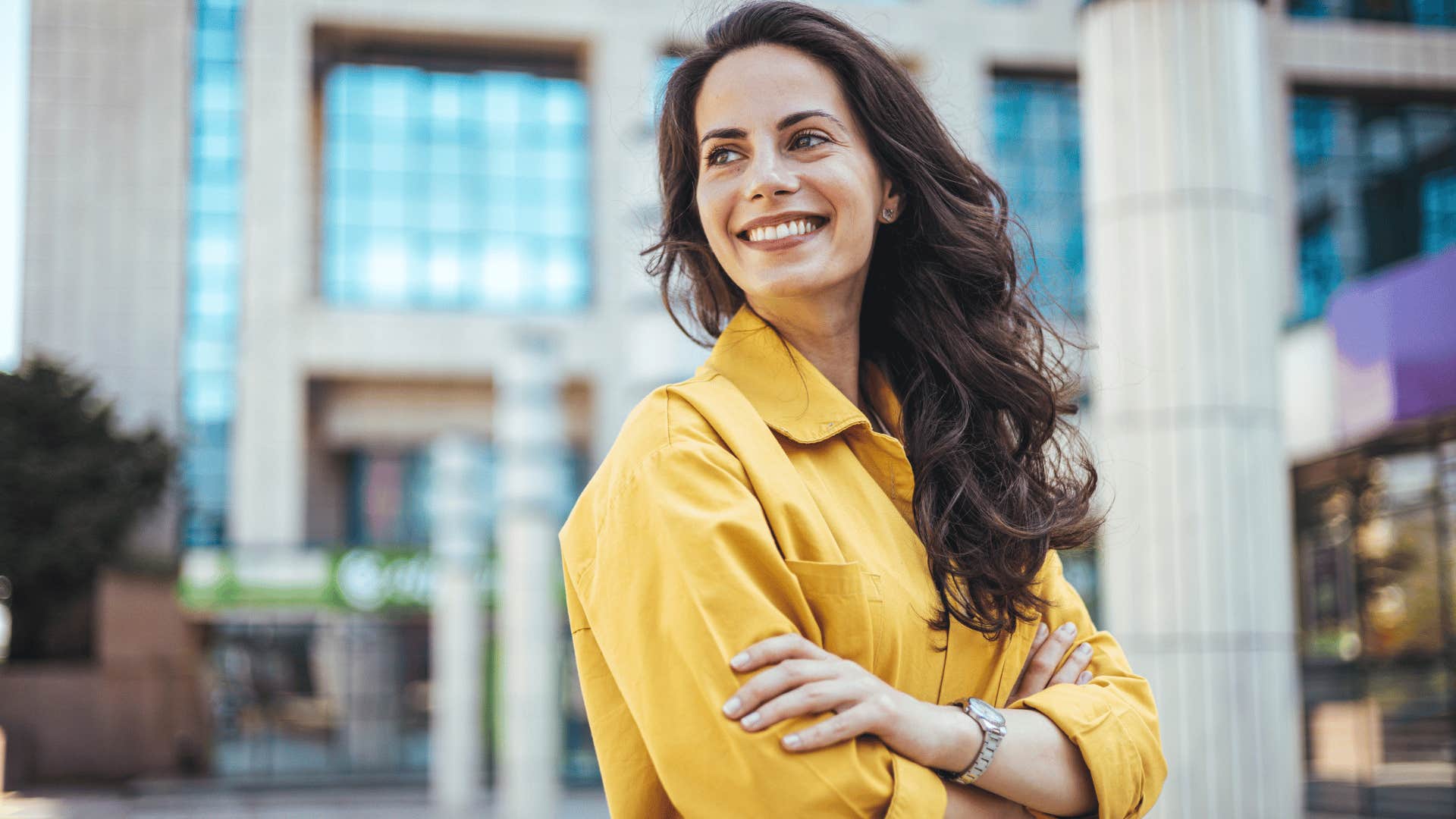 woman in yellow shirt crossing arms confidently as she thinks it works for me