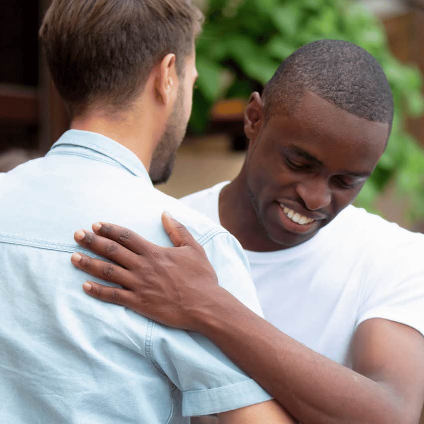 man greeting friend not isolating himself after heartbreak