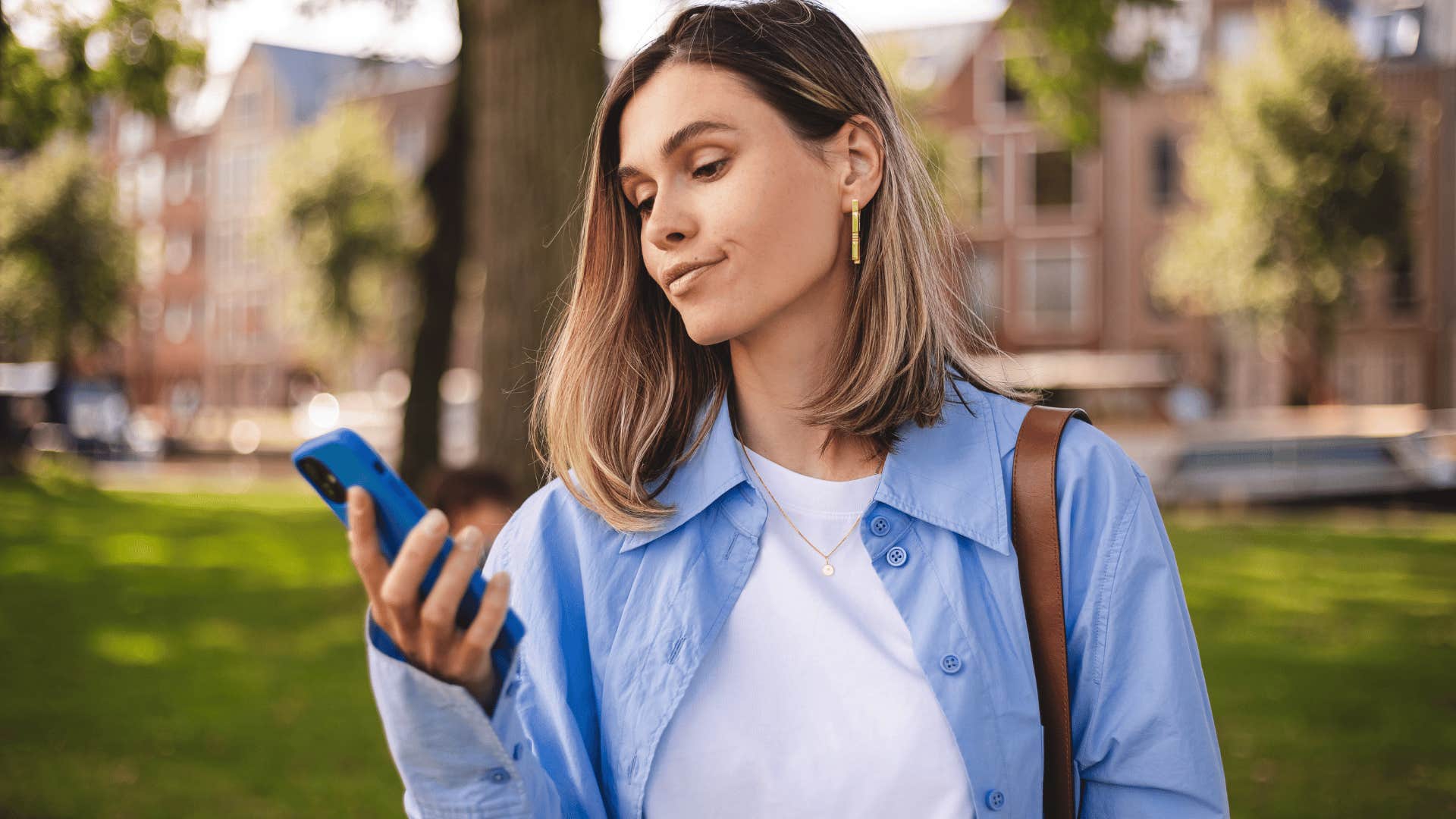 woman in white shirt rolling eyes at phone as she thinks here we go again