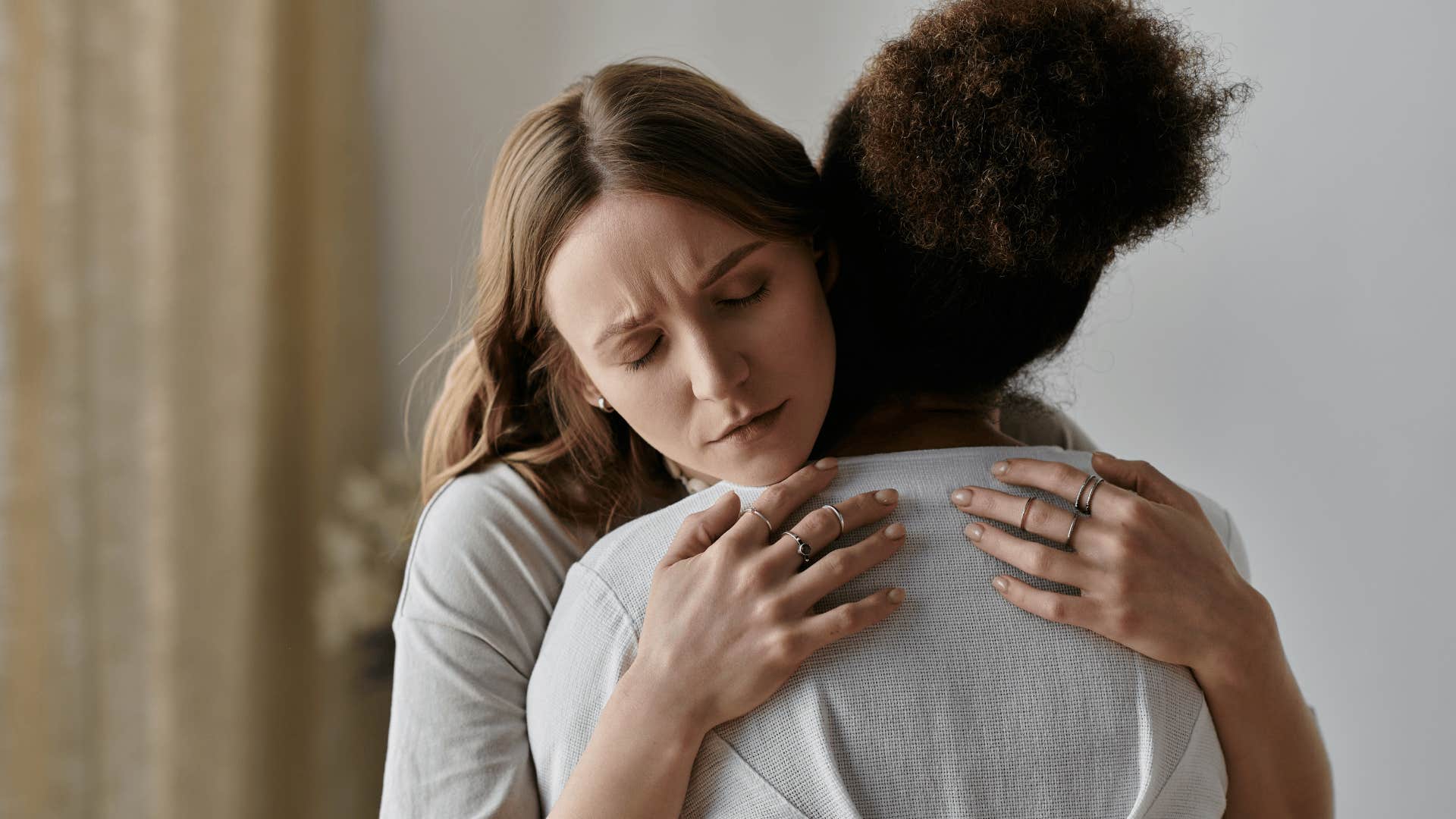 woman in white shirt hugging friend as she asks what do you need from me right now