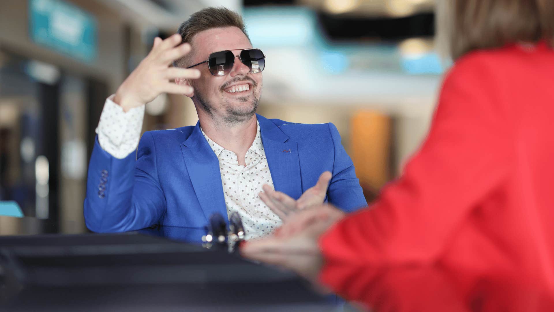 man in blue jacket smirking as he tells woman i tend to stand out
