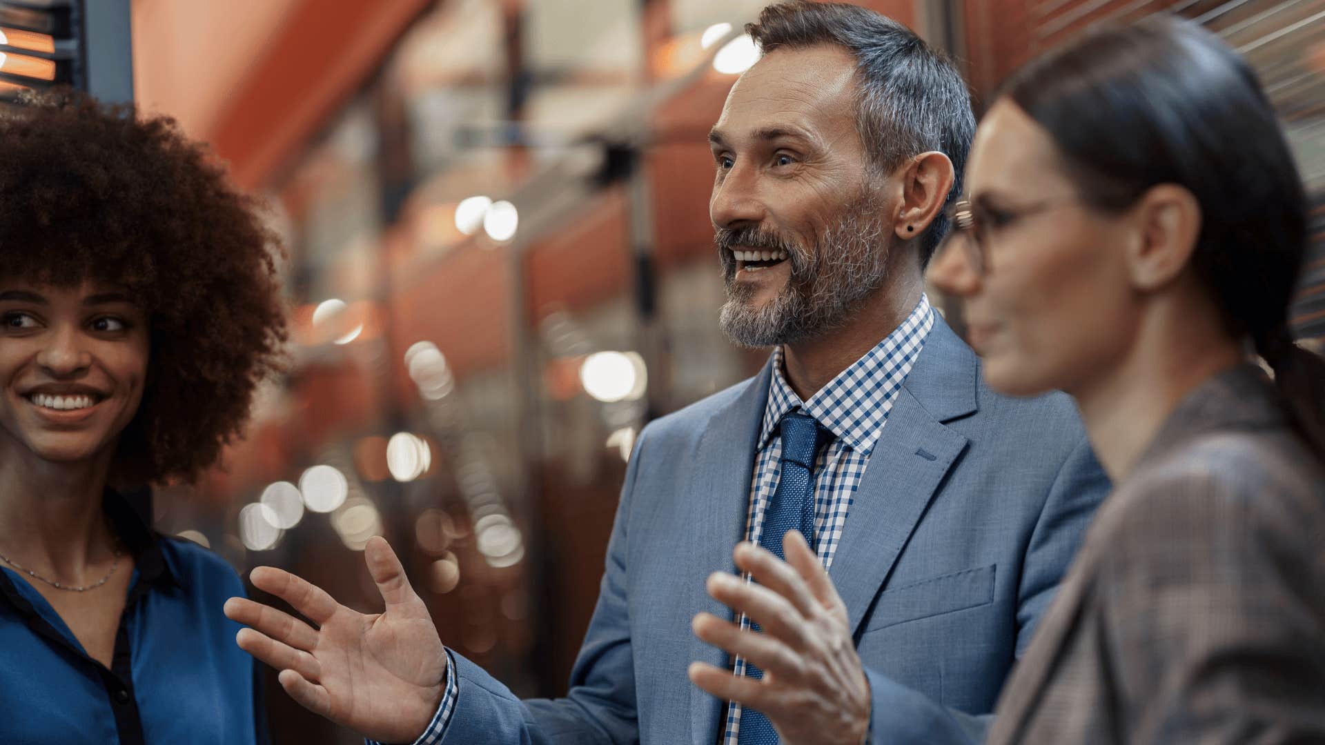 man in gray suit telling coworkers i'm not easy to replace
