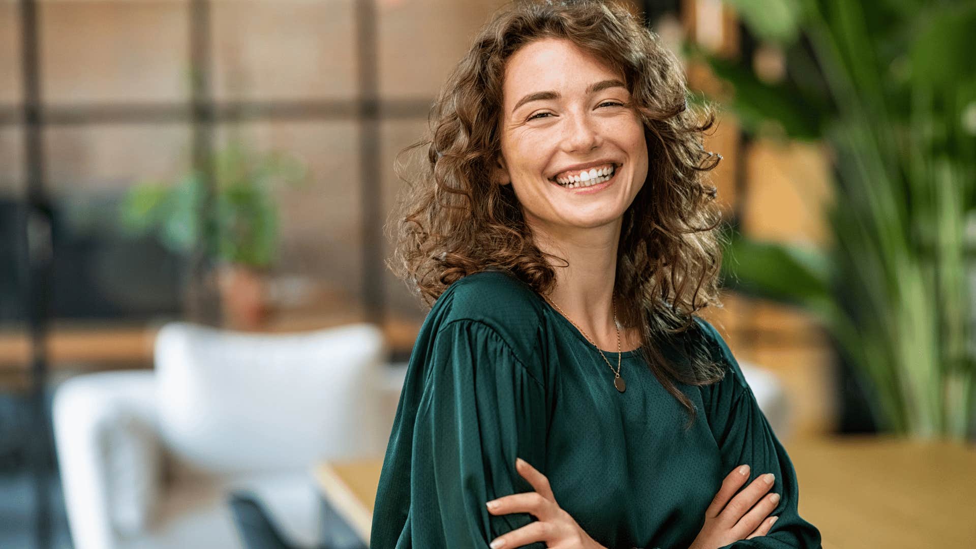 woman with green shirt smiling and crossing arms as she thinks i'm not your average person