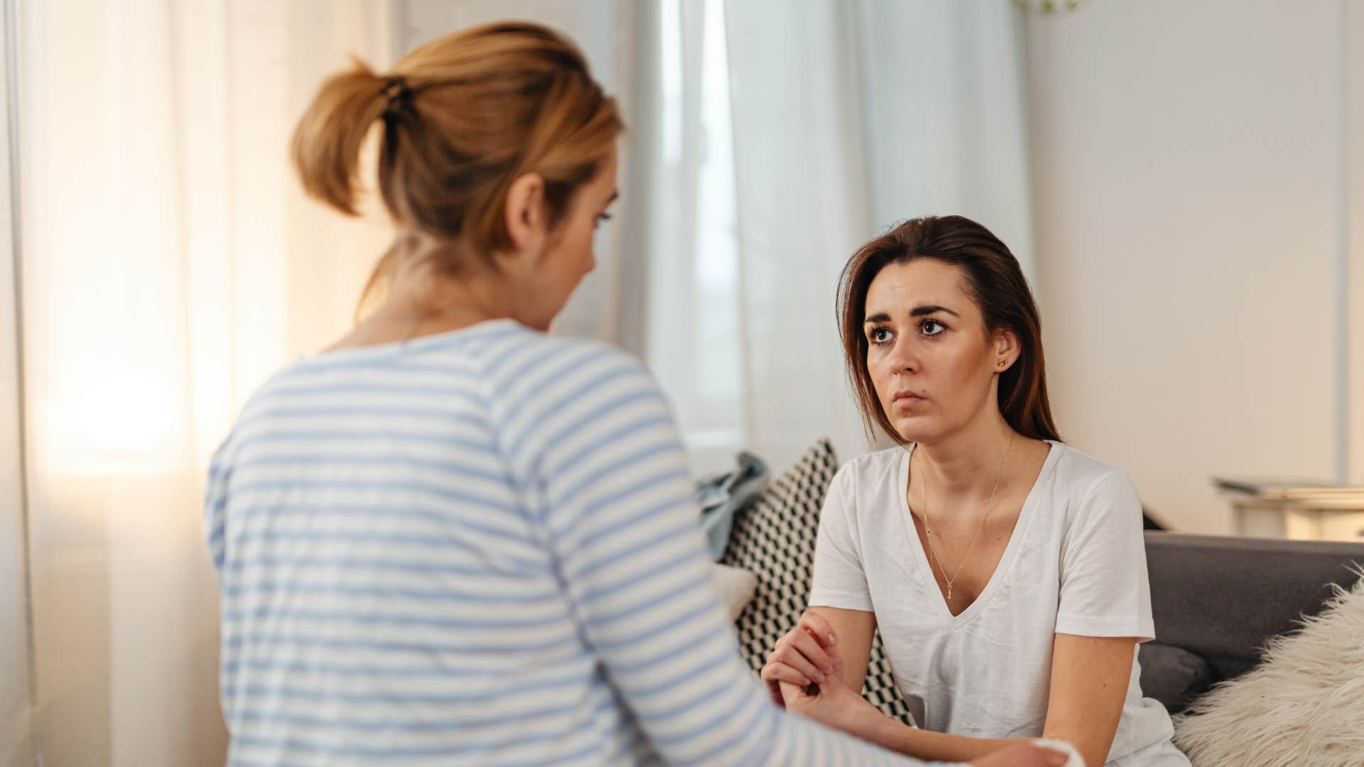 woman staying quiet while listening to her friend